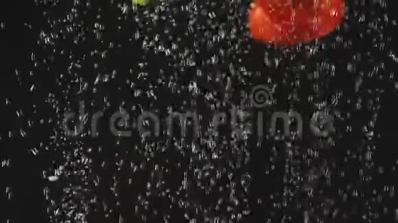 番茄片在黑色背景下落入水中新鲜蔬菜放在有气泡的水中有机食品健康视频的预览图
