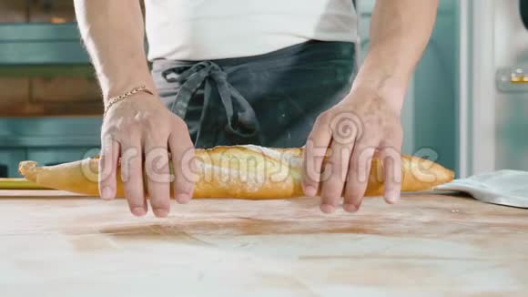面包师把新鲜面包撕成两半男性双手打破布袋视频的预览图