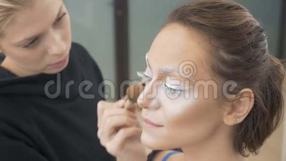专业化妆师做模特的化妆涂上一层特殊的油漆筹备工作视频的预览图