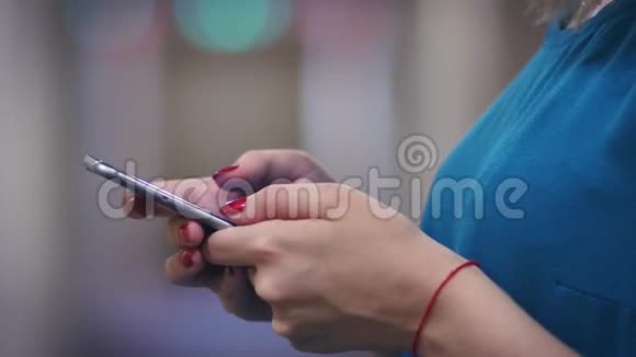女性手拿红线触摸屏幕手机侧视视频的预览图