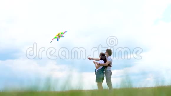 年轻的一家人一对夫妇在蓝天和云朵上放风筝视频的预览图
