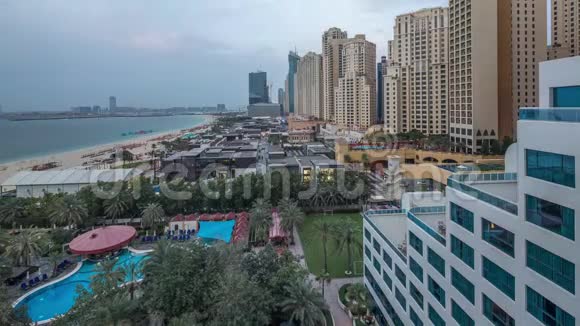 鸟瞰海滩和游客步行在JBR与摩天大楼日夜在迪拜阿联酋视频的预览图