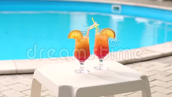 女性手的特写镜头在泳池边喝鸡尾酒视频的预览图