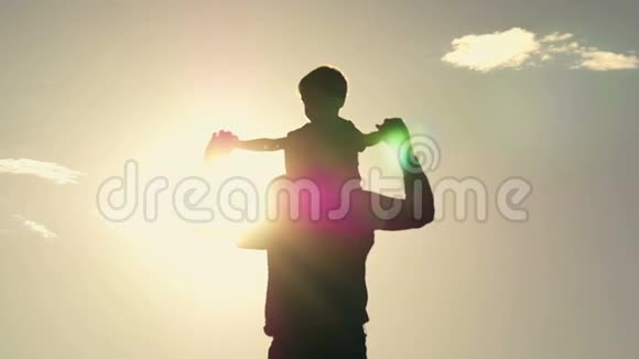 父亲在夕阳的背景下把儿子抱在肩上视频的预览图