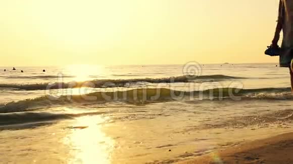 穿着裙子的女孩正在海边和日落散步视频的预览图