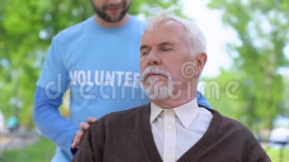 男性志愿者微笑着向老年退休金领取者社会工作者支持慈善机构视频的预览图