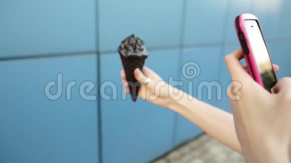 现代女孩在智能手机上拍冰淇淋有选择的焦点视频的预览图