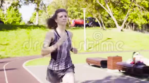 在运动场跑步的年轻女子视频的预览图