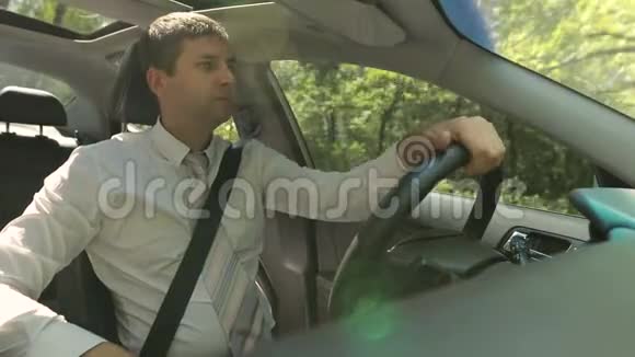 一个英俊严肃的男人在农村公路上开车视频的预览图