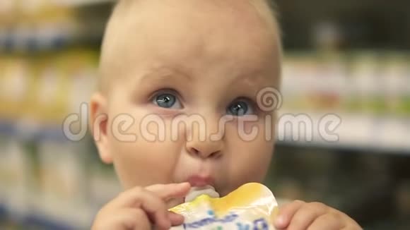 小婴儿喝着一个塑料瓶的果汁坐在超市的手推车里口渴的小孩和视频的预览图