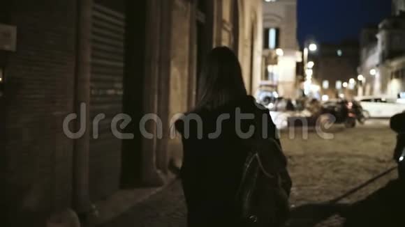 后景年轻时尚的女人走在荒无人烟的小巷深夜到主街城市道路视频的预览图