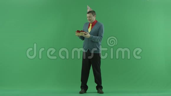 成年男子展示他的生日礼物绿色彩色钥匙背景视频的预览图