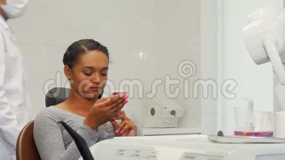 年轻开朗的女人和她的牙医对着镜头微笑视频的预览图