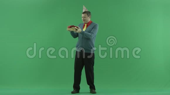 搞笑的成人男子打开生日礼物绿色镀铬键背景视频的预览图