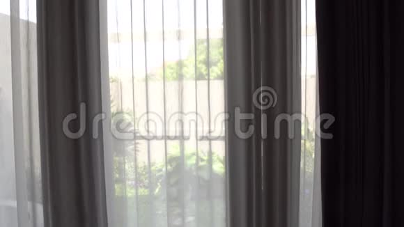 穿着白色浴袍长发的女人站在窗边喝水视频的预览图