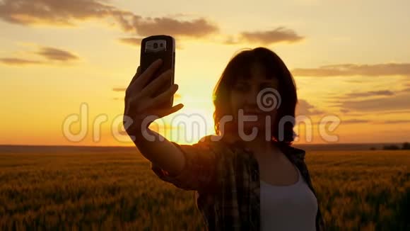 小女孩在美丽的夕阳下在麦田的背景下视频的预览图