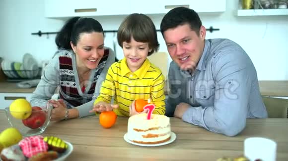 厨房里的小男孩和爸爸妈妈一起玩水果很可爱的男孩和他一起庆祝生日视频的预览图