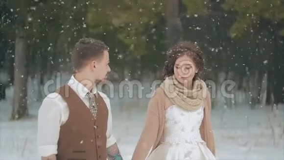 在冬天的圣诞大雪中一对爱侣走着视频的预览图