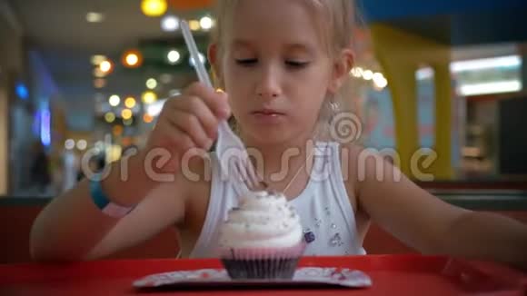 可爱的小女孩正在咖啡馆里吃蛋糕视频的预览图