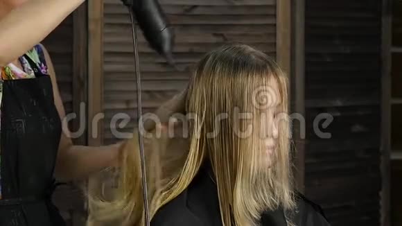 美容院的美女专业的理发师使用吹风机慢动作视频的预览图