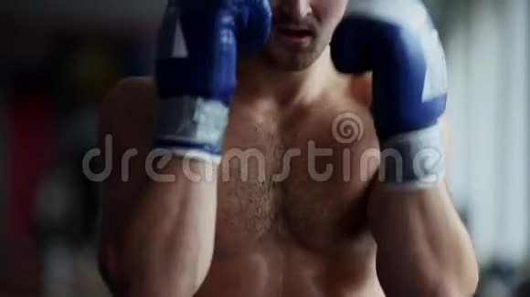 戴拳击手套的人拳击在镜头前特写镜头年轻人冲拳的特写拳击手进行上切视频的预览图