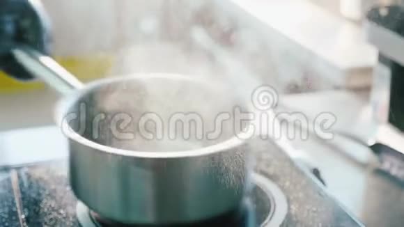 厨师手在手套混合一个蒸和嘶嘶的食物在酱汁锅视频的预览图
