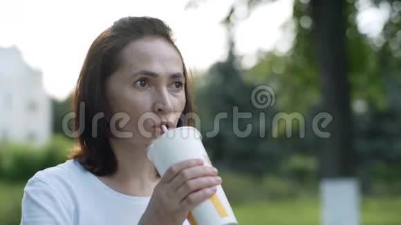 一个漂亮的女人正在用吸管喝一杯鸡尾酒视频的预览图