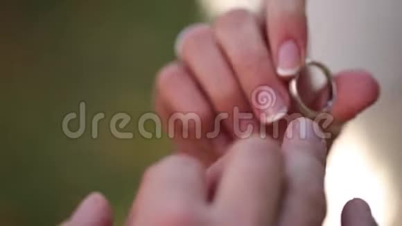 婚礼戒指宏观特写把戒指戴在手指上的白金钻石珠宝视频的预览图