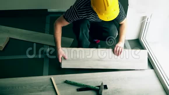 无法辨认的男性工人黄色安全帽安装地板视频的预览图