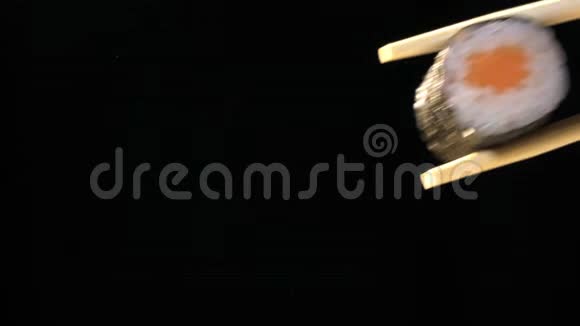 乌黑背景下筷子中的寿司视频的预览图