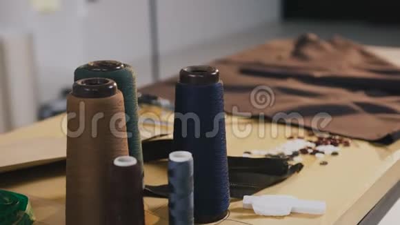 时装设计师工作室阿泰利埃桌子上摆着时尚的装饰物上面有一圈线剪刀电表纸巾视频的预览图