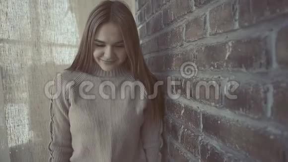 年轻女子在慢镜头中沿着砖墙行走的肖像视频的预览图