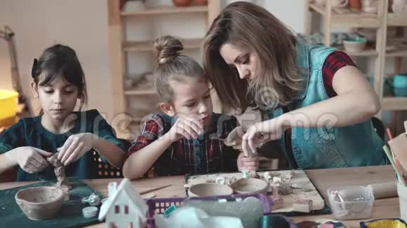 母亲和女儿热情地用陶器中的粘土塑造视频的预览图