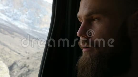 一个会说话的留着胡须的嬉皮士男性坐在车后座两边沉思的特写照片视频的预览图