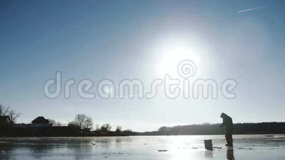 冬季捕鱼冬天阳光明媚的一天湖上的渔夫视频的预览图