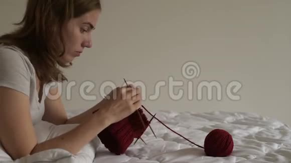 年轻女子在床上编织视频的预览图