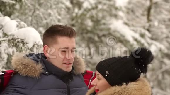 男人在雪地公园里用毯子盖住他的女孩视频的预览图