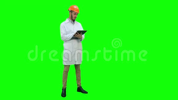 穿白色外套的土木工程师在绿色屏幕上准备报告铬键视频的预览图