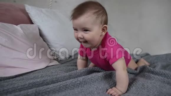 快乐的新生儿在床上爬行视频的预览图