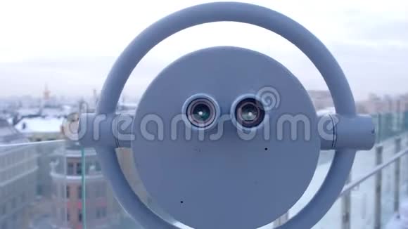 冬季城市楼顶观景台用望远镜观察视频的预览图
