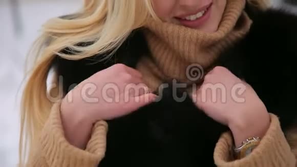 贴身的女孩裹着一件温暖的黑色毛皮外套视频的预览图