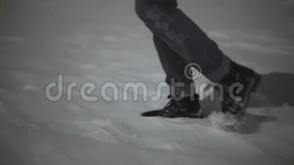 女人的特写镜头她的脚在雪地上行走斜射慢的月光视频的预览图