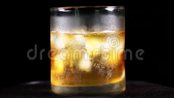 桌子上有冰块的威士忌酒杯视频的预览图