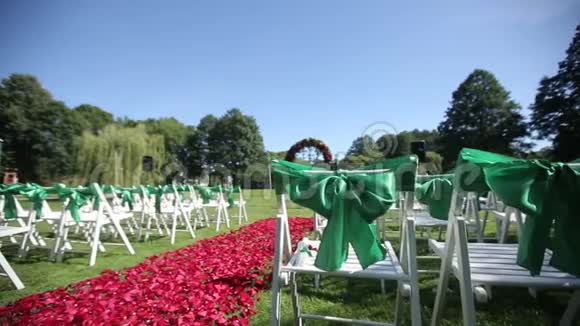 在开放仪式上摆放鲜花和装饰品的绿色结婚椅视频的预览图