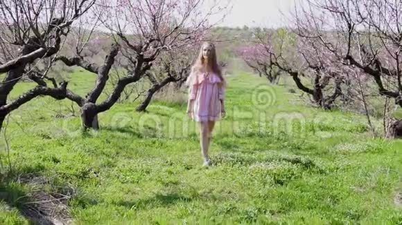 在花树的花园里一个穿着裙子的金发女孩视频的预览图