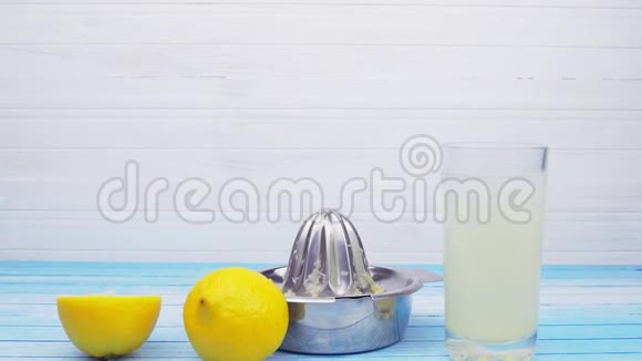新鲜挤压生物有机柠檬与不锈钢榨汁机和玻璃充满柠檬汁视频的预览图