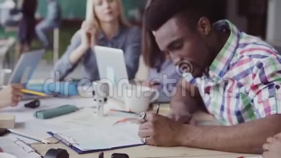 年轻英俊的非洲男人签了一份合同一群人在办公室的背景上鼓掌慢节奏视频的预览图