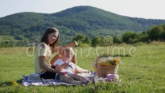 妈妈在户外和一个孩子玩孩子和妈妈一起在美丽的山景上玩视频的预览图