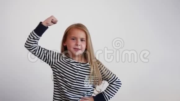 一个有趣的女孩握紧拳头显示出力量女孩模仿强壮的男人视频的预览图