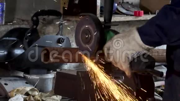工人在工厂使用角磨机并投掷火花框架穿着防护制服切割金属视频的预览图